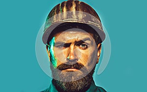 Serious construction worker in hard hat. Handsome confident male builder in safety helmet. Bearded man in hardhat