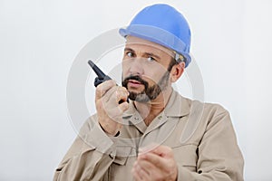 serious construction worker talking with walkie talkie