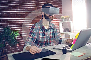 Serious creative businessman using 3D video glasses and laptop