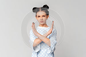 Serious dark-haired teen girl crossing arms and palms doing negative sign, prohibit, forbid smth bad, standing in trendy t shirt