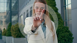 Serious displeased angry caucasian woman girl businesswoman business lady showing stop gesture palm hand outdoors reject