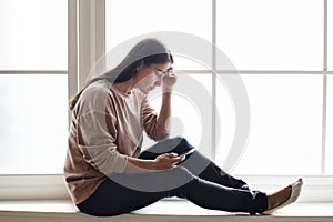 Serious and distressed woman using a smartphone