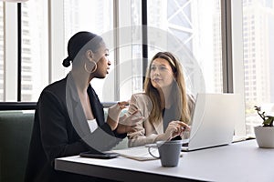 Serious diverse business colleagues meeting in coworking cafe