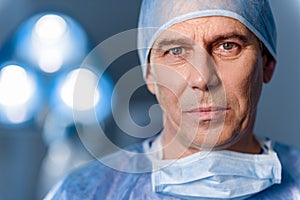 Serious doctor standing in operating room photo