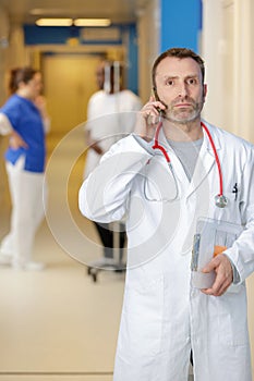 serious doctor talking on mobile phone at hospital