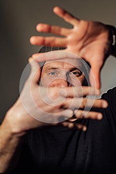 Serious dramatic man looking away while standing against black studio background