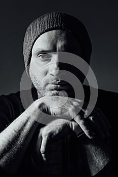 Serious dramatic man looking away while standing against black studio background