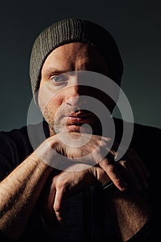 Serious dramatic man looking away while standing against black studio background