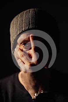 Serious dramatic man looking away while standing against black studio background