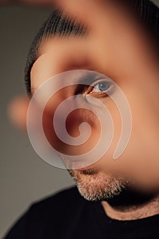 Serious dramatic man looking away while standing against black studio background