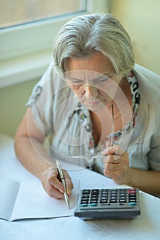 Serious elderly woman with calculator