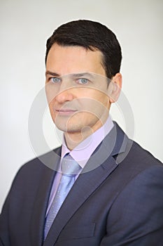 Serious elegance brunet man is posing next to photo