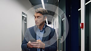 Serious employee texting smartphone in office. Confident businessman using phone