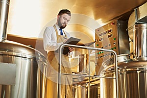 Serious engineer inspecting brewery process.