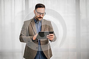 Serious entrepreneur making business plan on digital tablet at office