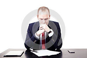 Serious European businessman in red tie at the table thought bef