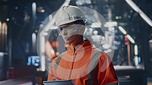 Serious factory inspector looking industrial facility holding tablet close up.