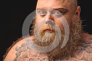Serious fat man with tattoo on body