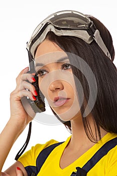 Serious female construction worker talking with a walkie talkie