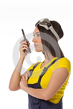 Serious female construction worker talking with a walkie talkie