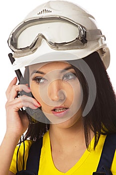 Serious female construction worker talking with a walkie talkie