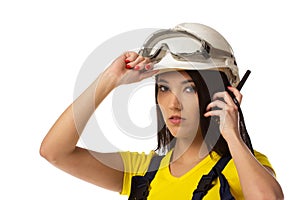 Serious female construction worker talking with a walkie talkie
