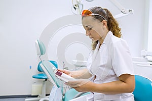 Serious female dentist doctor reading annotation of medicine