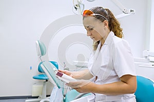 Serious female dentist doctor reading annotation of medicine photo