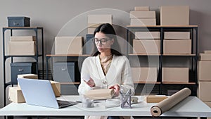 Serious Female Director Preparing Package To Send