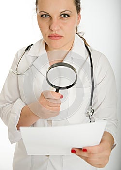 Serious female doctor analyzing document