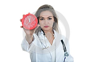 Serious female doctor holding clock.