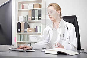 Serious Female Doctor Using her Desktop Computer