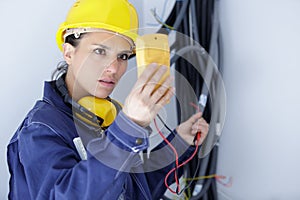serious female electrician reading multimeter