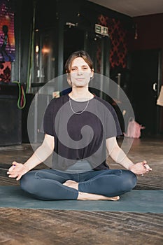 Serious female new yoga teacher resting in easy pose (sukhasana) in her vinyasa flow yoga practice