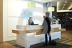 Serious female receptionist worker standing at hotel counter