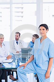 Serious female surgeon with colleagues in meeting