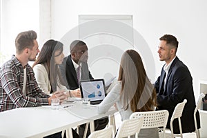 Serious focused multi-ethnic team listening to leader speaking a