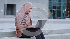 Serious focused muslim young business woman freelancer Islamic girl student in hijab female user uses computer