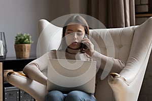 Serious focused remote worker, freelancer talking on mobile phone