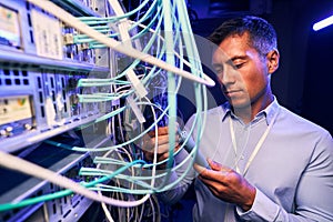 Serious focused IT technician testing cabling performance