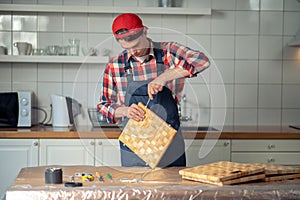 Serious focused woodworker making a straw box