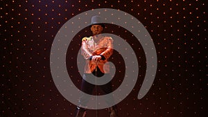 Serious gentleman with stick in light of spotlight on stage