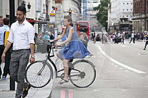 Serious girl in a blue dress with polka dots crossing the road o