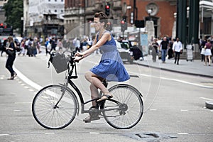 Serious girl in a blue dress with polka dots crossing the road o