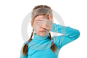 Serious girl closes eyes with her left hand, isolated on the white background