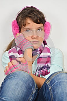 Serious girl with ear muffs and trimmed gloves