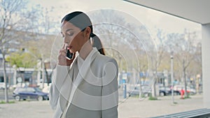 Serious girl talking phone walking city building closeup. Woman going to office