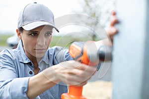 serious girl using battery drill