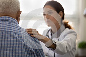 Serious GP doctor giving support to elderly patient