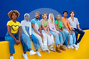 Serious group of multi-ethnic young people sitting on a wall